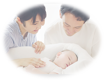 赤ちゃんを優しく見つめるパパとママのイメージ写真
